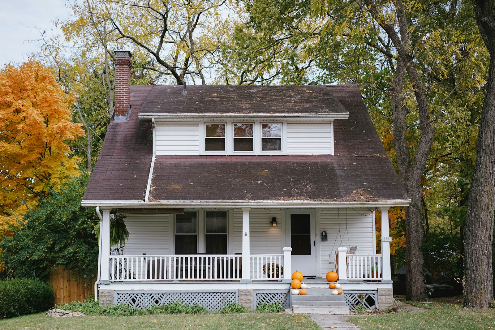 White cottage with a covered porch and painted railings